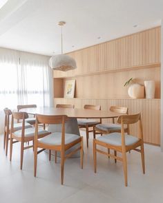 a dining room table surrounded by chairs and vases