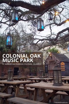 an outdoor picnic area with wooden tables and lanterns