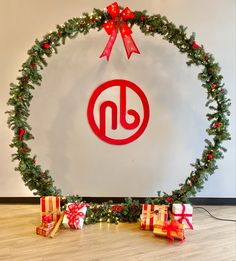 a christmas wreath and presents are in front of a wall with the dnc logo on it