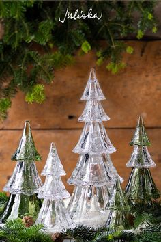 christmas trees are shown in front of a wooden background with text overlay that reads, mix and match a glistering forest of our berry & thread stackable glass trees