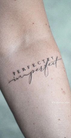 a person with a tattoo on their arm that says perfectly imperfectity in cursive writing