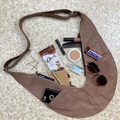 a purse with various items in it sitting on the floor