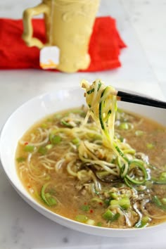 a white bowl filled with noodles and vegetables