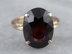 This beautifully structured, classic mounting holds a bold stone! This gem is a gorgeous deep red garnet, weighing in at over 11 carats. Garnets are known for their exceptional color and play of light, and this gem is opulent and sophisticated. Metal: 14K Yellow Gold Gem: Garnet 11.43 Carats Gem Measurements: 11 x 15 mm, Oval Ring Size: 6 Marks: "14K" Stamped on the inside band Elegant Faceted Ruby Ring For Formal Occasions, Elegant Formal Faceted Ruby Ring, Pyrope Garnet, Right Hand Ring, Garnet And Gold, Gold Statement Ring, Right Hand Rings, Hand Ring, Oval Ring