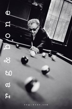 a man leaning over a pool table with balls in front of him and looking at the ball