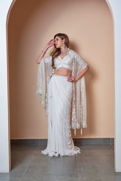 This gorgeous ivory floral machine work blouse, paired with skirt and dupatta is crafted with georgette and organza. This piece is embellished with feminine details and an undaunted elegance. Delivery Period: 2-3 weeks Elegant Chiffon Choli For Festive Occasions, Elegant Chiffon Lehenga With Sheer Dupatta, White Gown With Sheer Dupatta In Traditional Drape, Chiffon Sharara For Wedding With Traditional Drape, Wedding Saree Set In Chiffon, Wedding Chiffon Sharara With Traditional Drape, Chiffon Lehenga For Wedding Party, White Gown With Sheer Dupatta For Reception, Elegant Chiffon Lehenga For Festive Occasions