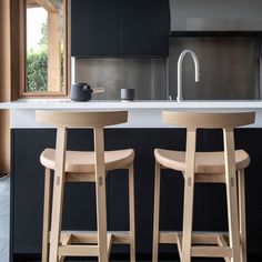 two wooden stools in front of a kitchen counter