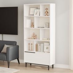 a living room with a gray chair and white bookcase in front of a flat screen tv