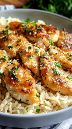 a white bowl filled with rice covered in chicken and parmesan sprinkles