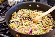 a skillet filled with meat and vegetables cooking on the stove