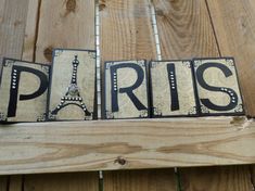 the word paris written in black and white letters on a wooden planked surface with wood slats