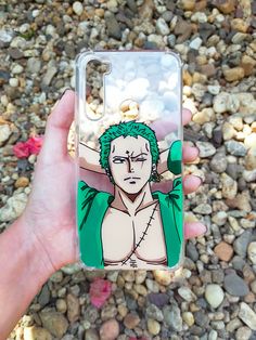 a person holding up a cell phone case with an image of one piece of the same character on it