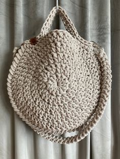 a crocheted purse hanging on a curtain