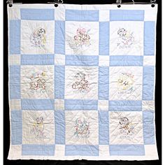 a blue and white quilt with embroidered pictures on it