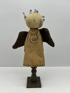 an old fashioned doll with black wings and brown dress