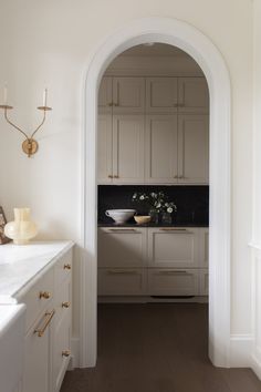 an archway leading into a kitchen with white cabinets