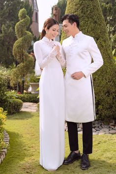 a man and woman dressed in white standing next to each other