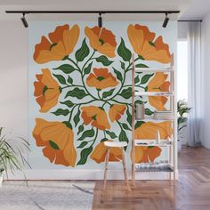 an orange and green floral wall mural on a white wall in a room with wooden floors