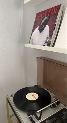 a record player sitting on top of a table next to a wall with a magazine