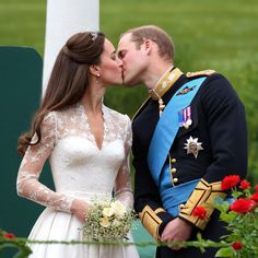 a man and woman kissing each other in front of flowers