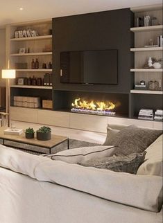 a living room filled with furniture and a flat screen tv mounted on the wall next to a fire place