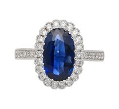 This vintage, retro, Art Deco-style ring features a GIA Certified 2.38-carat oval cut blue sapphire of Cambodian origin surrounded by 36 round-cut diamonds forming a tight halo,  weighing 0.39 carats total. All of these diamonds are set in an 18K white gold ring with stunning vintage a milgrain finish. Weighing 4.42 grams, this ring is a perfect blend of classic design and modern sophistication, ideal for those who appreciate the allure of vintage jewelry with a contemporary twist.  Item Details Blue Oval Gia Certified Halo Ring, Classic Blue Sapphire Ring With Oval Cabochon, Classic Blue Halo Ring, Vintage Blue Oval Sapphire Ring, Blue Oval Halo Ring With Center Stone, Blue Sapphire Oval Halo Ring, Oval Blue Sapphire Halo Ring, Oval Sapphire Halo Ring In Blue, Oval Blue Halo Ring With Brilliant Cut