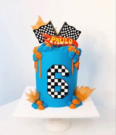 a blue birthday cake with the number six on it's side and flags in the middle