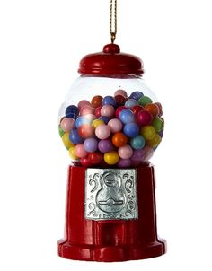 a red gummy machine filled with lots of different colored candies next to a gold coin