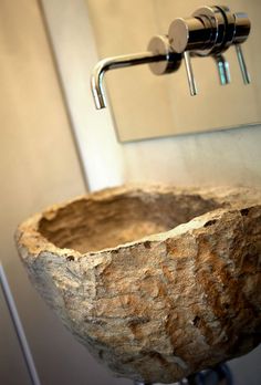 a stone sink in a bathroom next to a mirror