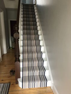 the stairs in this house are lined with striped carpet