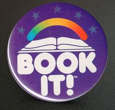 a purple button with the words book it in white letters and a rainbow on top