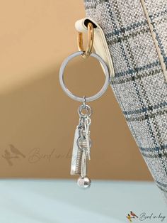 a close up of a key chain attached to a purse with a ring on it