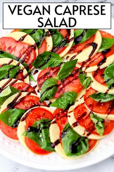 a white plate topped with sliced tomatoes and spinach