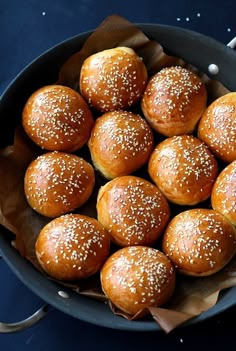 a pan filled with buns covered in sesame seeds