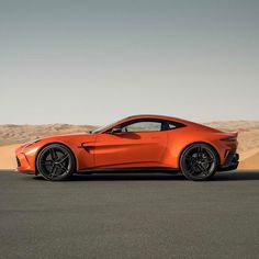 an orange sports car parked in the desert