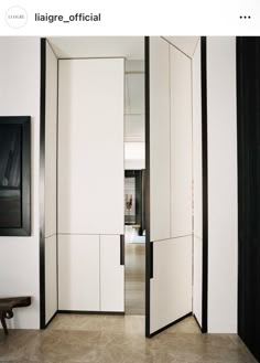 an open room divider in the middle of a hallway with black and white walls