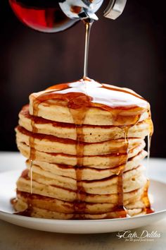 a stack of pancakes with syrup being drizzled on top