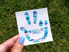 a person holding up a piece of paper with the shape of a hand print on it