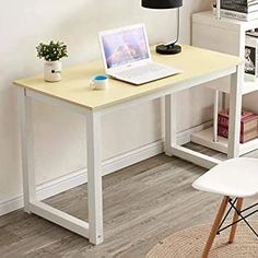 a laptop computer sitting on top of a wooden desk next to a white chair and bookshelf