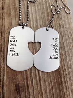 two dog tags with words on them that say i hold you in my heart and the other says,