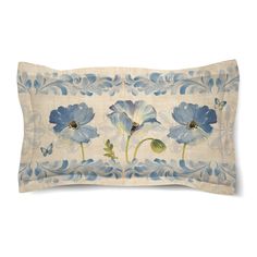 an embroidered pillow with blue flowers and leaves on it's side, in front of a white background