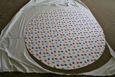 an image of a round table cloth on the floor with scissors and tape around it