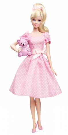 a barbie doll holding a pink teddy bear in her hand and wearing a polka dot dress