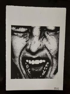 a black and white photo of a man's face with teeth open in front of him