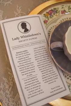 a tea cup and saucer on a table with a menu for lady whistedown's society papers