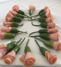 a white plate topped with green beans and ham wrapped in rolled up doughnuts