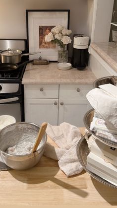 the kitchen counter is cluttered with dishes and utensils, including a mixing bowl