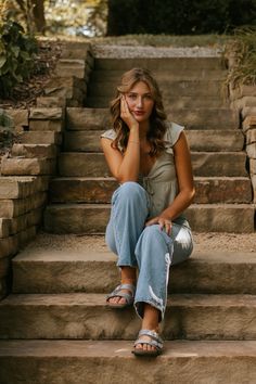 a woman sitting on steps with her hand under her chin