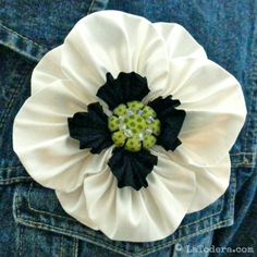 a white flower with black centers is in the back pocket of someone's jeans