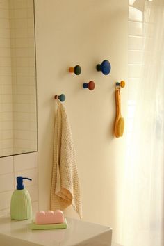 a bathroom with a sink, mirror and soap dispenser on the wall